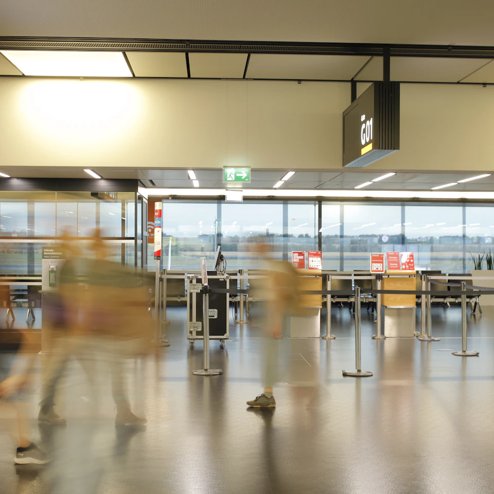 A bright modern airport terminal with daylight pouring through glass walls