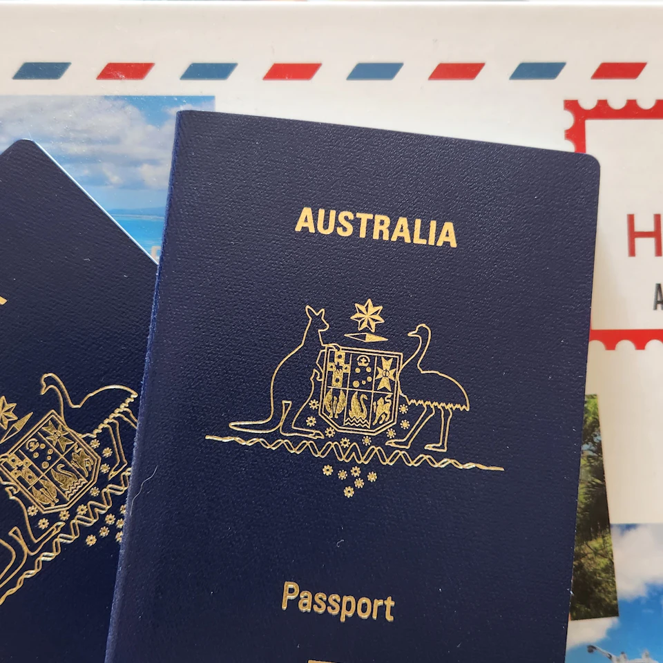 A clean bright flatlay of passports on colorful sunny travel postcards